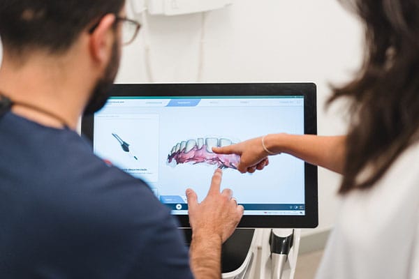Prótesis Dental en Barcelona: Diseño digital de puente dental sobre escaneo intraoral en monitor.