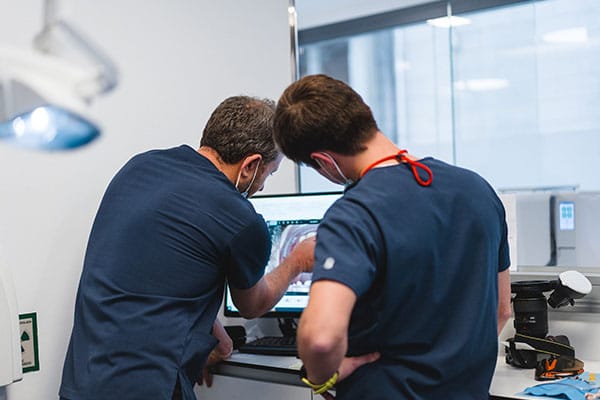 Prótesis Dental en Barcelona: Odontólogos revisan en ordenador el diseño CAD/CAM de una incrustación cerámica